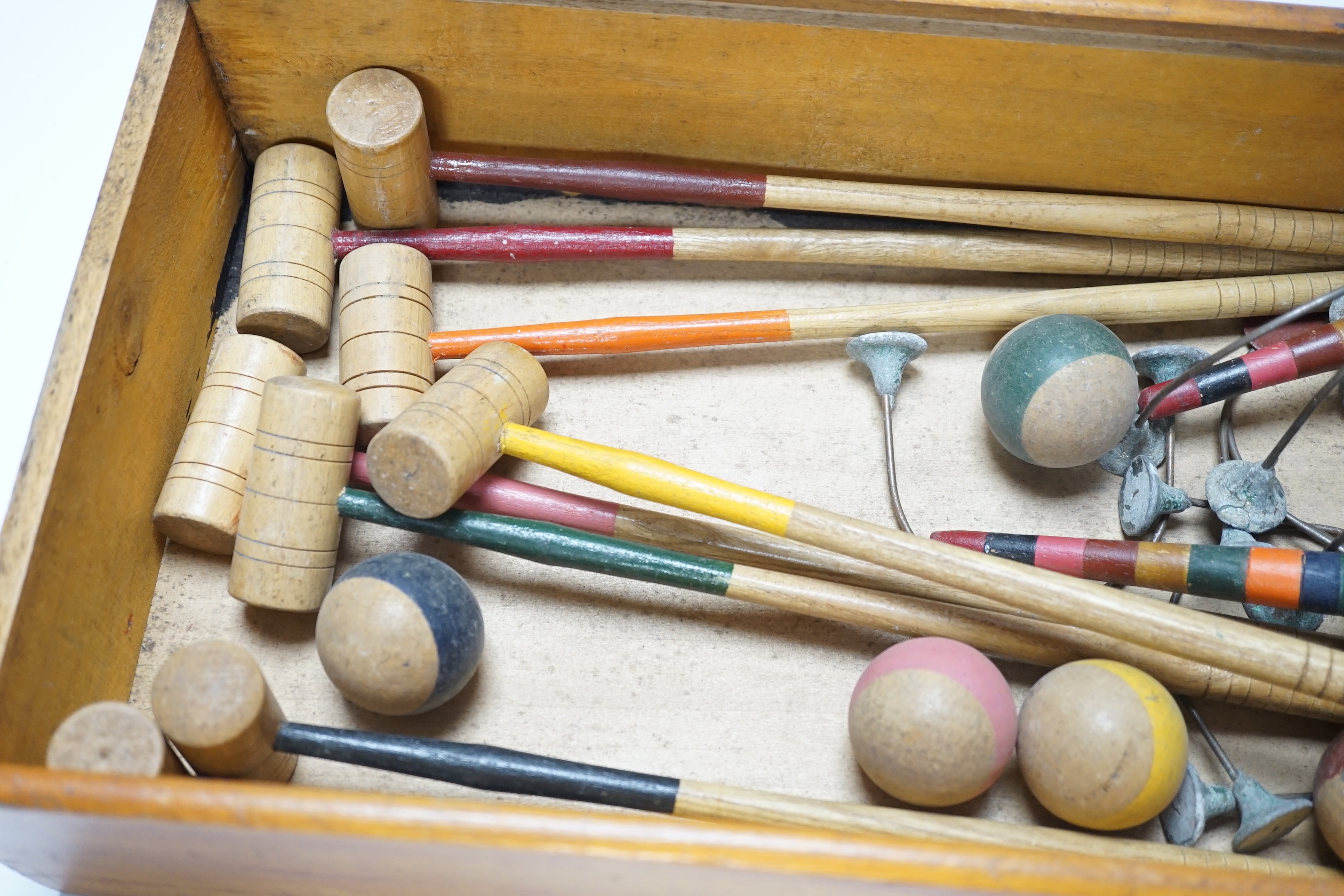 A boxed table croquet set with eight painted bats and six balls